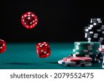 Casino Chips Stack and Flying Dices on Green Poker Table.
