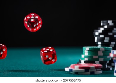 Casino Chips Stack and Flying Dices on Green Poker Table.