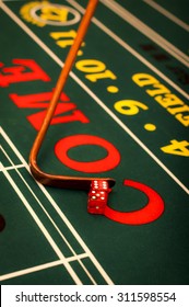 Casino Dealer Pushing A Pair Of Dice On A Craps Table