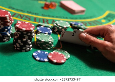 Casino, juegos de azar y concepto de entretenimiento - pila de fichas de póquer en una mesa verde.