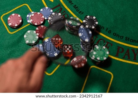 Casino, gambling and entertainment concept - stack of poker chips on a green table.