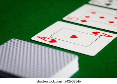 casino, gambling, poker, and entertainment concept - close up of playing cards on green table surface - Shutterstock ID 242602546