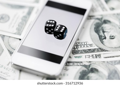 Casino, Online Gambling, Technology And Fortune Concept - Close Up Of Black Dice, Smart Phone And Dollar Cash Money