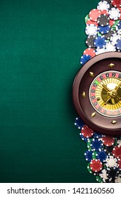 Casino Roulette Background With Roulette Drum,Casino Chips On Green Felt Table. Overhead View With Copy Space.