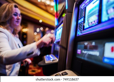 Casino Slot Games Play. Caucasian Woman In Her 30s Playing Slot Machine In The Casino.