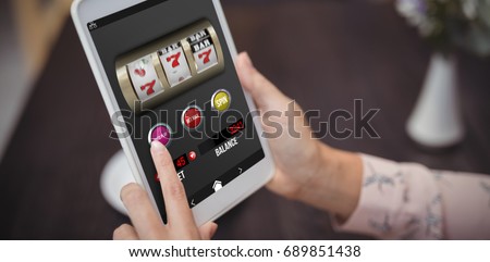 Casino slot machine game on mobile screen against close-up of woman hands using digital tablet