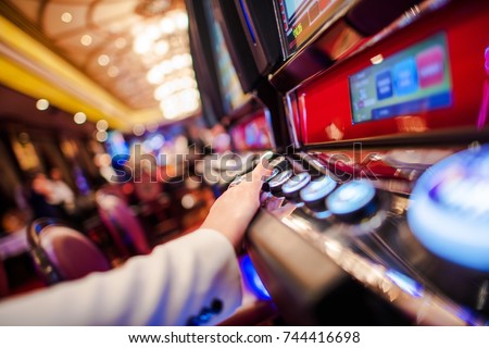 Casino Slot Video Games. Woman Playing Video Slot in the Casino. Hand on Betting Button Closeup Photo.