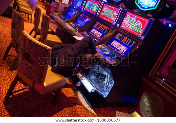 Casino technician staff inspecting casino\
machine. Miami, Florida. 22 march\
2018