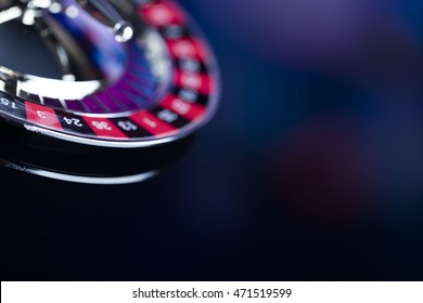 Casino theme. High contrast image of casino roulette, poker game, dice game, poker chips on a gaming table, all on colorful bokeh background. Place for typography and logo. - Powered by Shutterstock