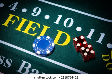 Casino-style dice and chips sit on the field space of a craps table. 