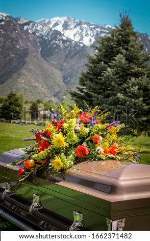 casket with flowers and mountain background