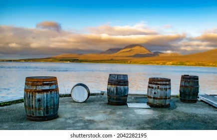 Casks And Barrels In A Whiskey Distillery Islay In Scotland Coast With Jura Behind