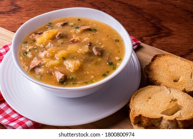 Cassava broth. Creamy broth made with cassava, sausage, bacon and meat. Accompanied by toast Top view Top view