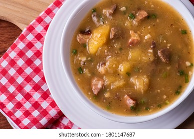 Cassava broth. Creamy broth made with cassava, sausage, bacon and meat. Top view