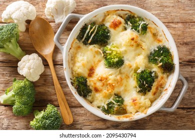 Casserole Blumenkohl und Broccoli gebacken mit Käsesoße in einem Topf, Nahaufnahme auf einem Holztisch. horizontale Draufsicht von oben