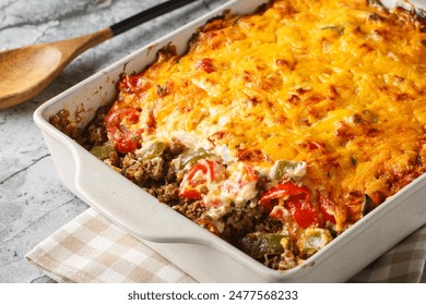 Casserole layers of ground beef, cheese, fresh vegetables and Jalapeno peppers baked closeup on the baking dish on the table. Horizontal
 - Powered by Shutterstock