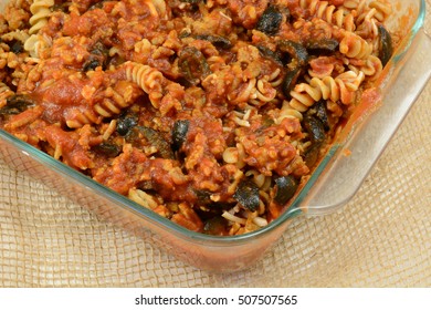 Casserole Preparation Of Cooked Whole Wheat Rotini Pasta, Ground Turkey Meat, Sliced Black Olives And Tomato Sauce In Glass Baking Dish