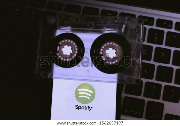 Cassette and phone screen with the Spotify logo\
which is a multiplatform music application.\
Sunday, November 17,\
2019, New York, United\
States.