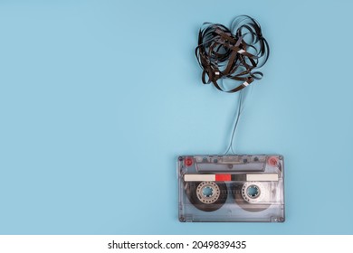 Cassette Tape Over Wooden Table With Tangled Ribbon. Top View.