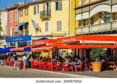 Cassis, France - August 2021 : Tourist Family Queuing At The Entrance Of A Restaurant On The Port Of Cassis