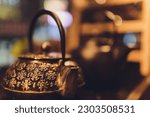 Cast iron black kettle on the table on a brown background. Tea ceremony.