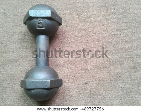 cast iron dumbbell and weight plates on floor