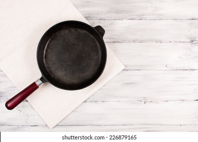 Cast Iron Frying Pan On A Wooden Background