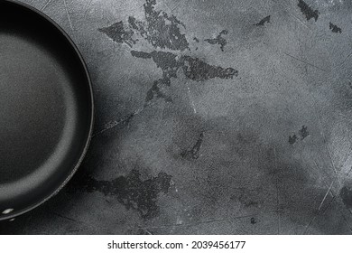 Cast iron frying pan set with copy space for text or food with copy space for text or food, top view flat lay, on gray stone table background