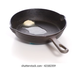 A Cast Iron Pan With Some Butter Melting In The Bottom Of It, Shot On White