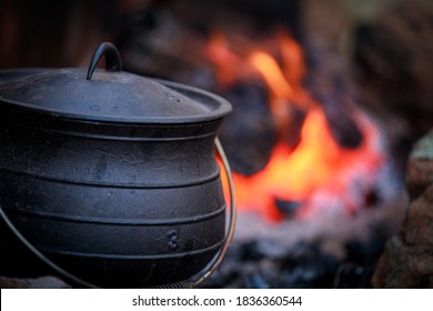 Cast iron pot cooking over red hot coles - Powered by Shutterstock