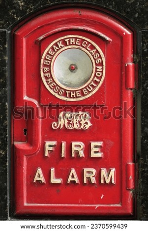Cast iron, push button, fire alarm box of the MFB Metropolitan Fire Brigade, circa 1920s, with ''break the glass and press the button'' legend, Central Business District-CBD. Melbourne-VIC-Australia.