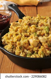 A Cast Iron Skillet With Corn Bread Stuffing With Chunks Of Turkey Meat