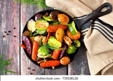 Cast Iron Skillet Of Roasted Autumn Vegetables, Overhead Scene On A Rustic Wood Background