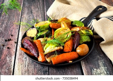 Cast Iron Skillet Of Roasted Autumn Vegetables, Against A Rustic Wood Background