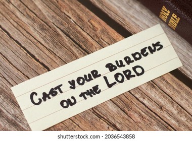 Cast your burdens, cares, troubles on the LORD. The biblical concept of faith and trust in God Jesus Christ. A handwritten inspiring quote from Holy Bible. Christian hope, belief, comfort. A close-up.