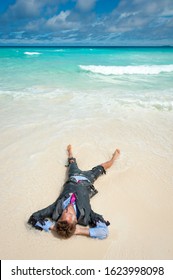 Castaway survivor businessman washed up on a tropical beach relaxing in a ragged torn suit - Shutterstock ID 1623998098