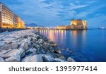Castel dell Ovo (Egg castle) in Naples, Italy, view from the seaside quay in blue evening light