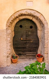 Castelgandolfo, Italy - 20-06-2022: A beautiful old wooden door of "fraschetta" as they call a wine cellar near Rome. The door is irregular, slightly rounded, reminiscent of hobbit dwellings.