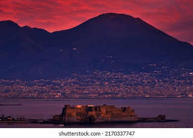 Castello di Nisida, Naples, twilight evening pink violet sunset. Town Napoli in Italy, travelling in the Europe. Urban landscape with city, sea, hills and Vesuvio Volcano. Beautiful sunset sky.