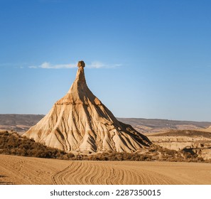 Castildetierra pyramidal rock formation of ocher tones formed by wind and water erosion in the Bárdenas Reales Natural Park, in Navarra under the summer sky in Spain