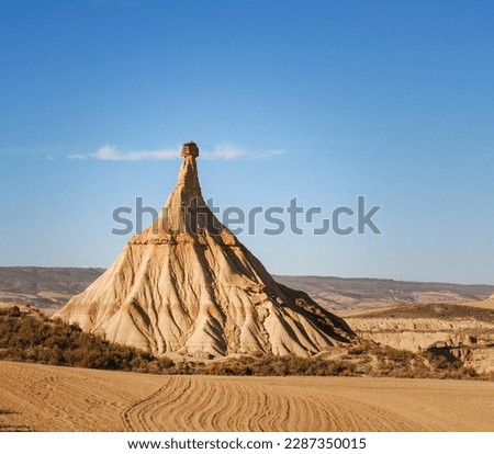 Castildetierra pyramidal rock formation of ocher tones formed by wind and water erosion in the Bárdenas Reales Natural Park, in Navarra under the summer sky in Spain