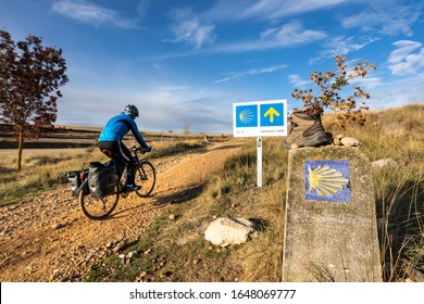 LEÓN / Castilla y León / SPAIN - 10/16/2019: Pilgrim advances on the Camino de Santiago with his bicycle on a sunny day through the lands of Spain.