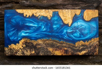 Casting blue epoxy resin burl wood cube on old table art background, Nature Afzelia wooden
