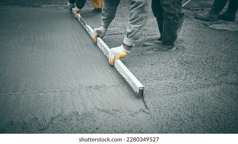 Cast-in-place work using trowels. Workers level cement mortar. Construction worker uses trowel to level cement mortar screed. Concrete works on construction site - Shutterstock ID 2280349527