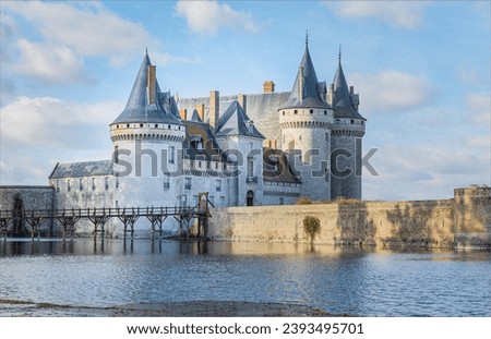 Castle across a maot with tall towers and a wooden walkway on a cool winter day