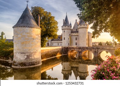 Castle Chateau Of Sully-sur-Loire At Sunset, France, Europe. It Is Landmark Of Loire Valley. Beautiful View Of Old French Castle In Sun Light. Wonderful Landscape With Fairytale Castle And Flowers. 