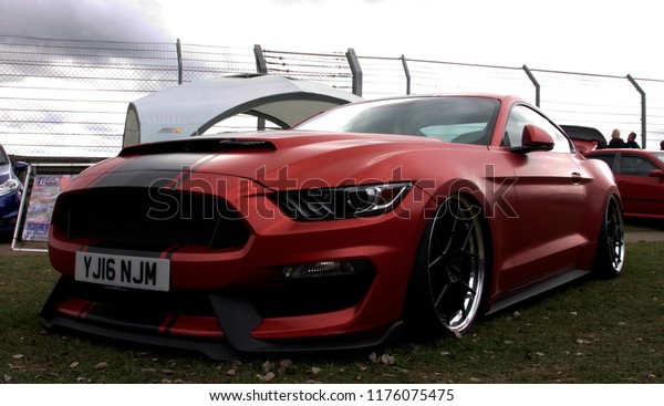 Castle Combe,\
Wiltshire, UK Sept 2018. Red Mustang Shelby with black stripe in a\
car event, close up,\
isolated