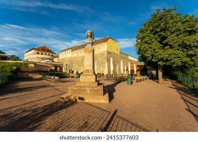 Špilberk Castle fort and grounds in Brno, Czech Republic with a statue and outdoor café on a sunny day with no people. The historic landmark castle was transformed into a Brno, Czechia city museum.