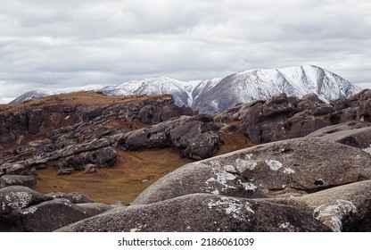 Castle Hill, Canterbury, New Zealand.

View of a beautiful rocky terrain on a cloudy day with snow topped mountains in the background. - Shutterstock ID 2186061039