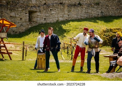 Castle Landstejn, South Bohemian, Czech Republic, 03 July 2021: Medieval summer market festival show, historical performance, men in antique costumes and armor playing dice and cards at wooden table.